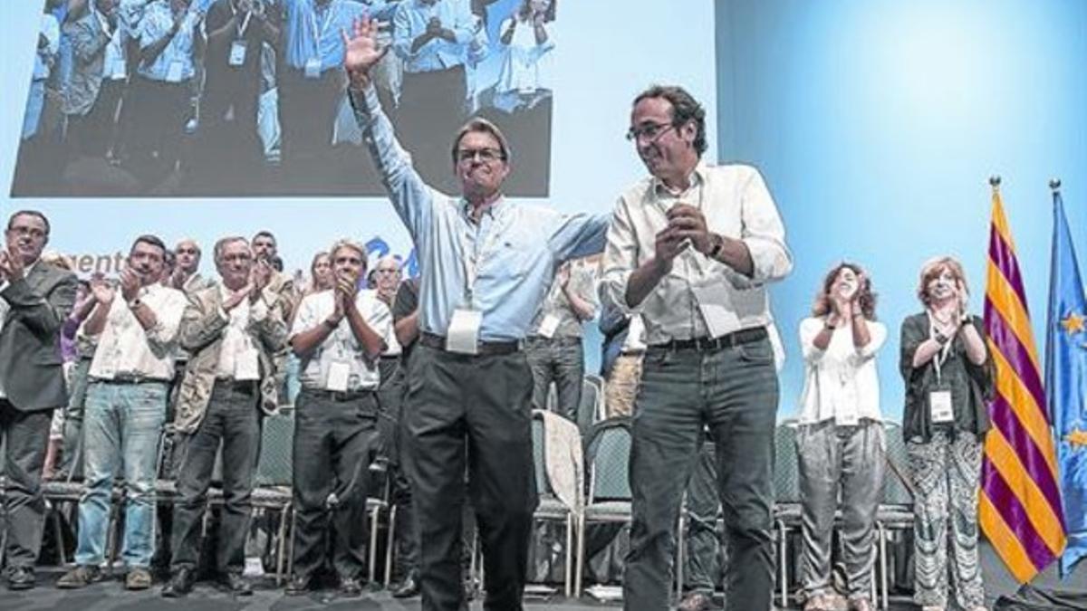 Artur Mas y Josep Rull saludan a la militancia tras darse a conocer la ratificación del nuevo consejo nacional de CDC.