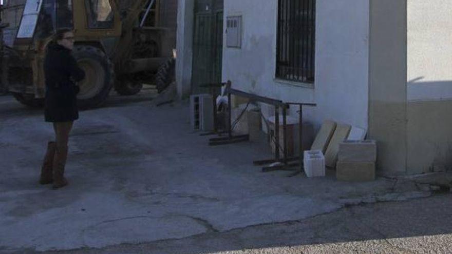 Una mujer junto a la vivienda asaltada en Madridanos.