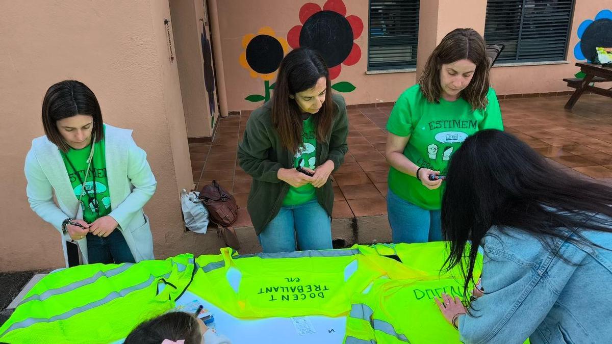 Madres y maestras preparan chalecos reivindicativos en el colegio Santa Bárbara de Benifaió.