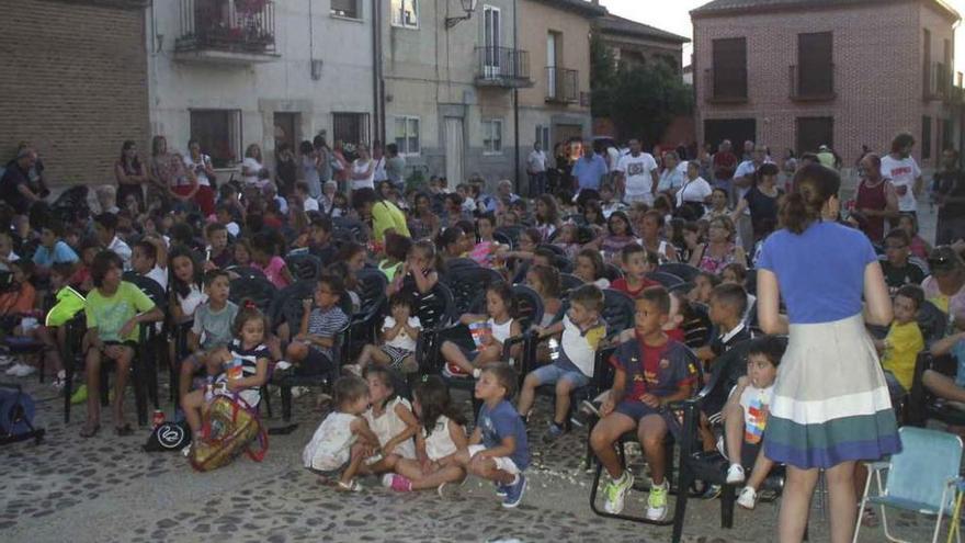 Un nutrido grupo de niños sigue con atención la película proyectada para ellos en la plaza del Carmen. Foto