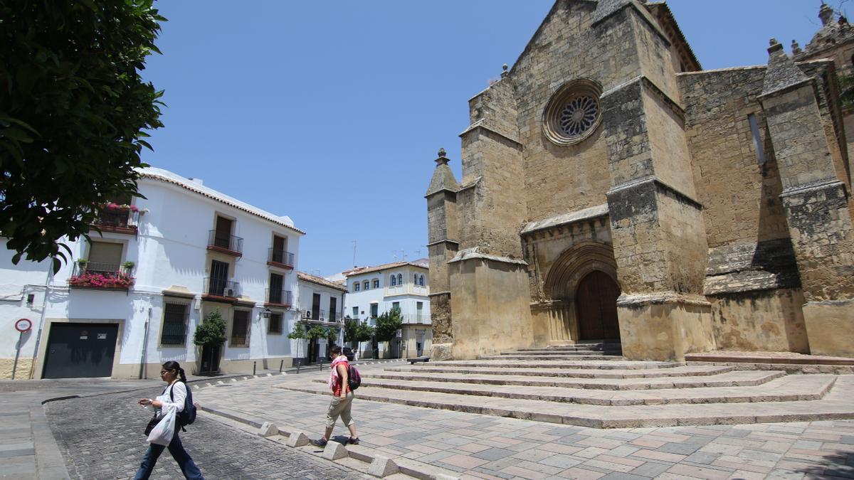 Dos personas caminan junto a la iglesia de Santa Marina.