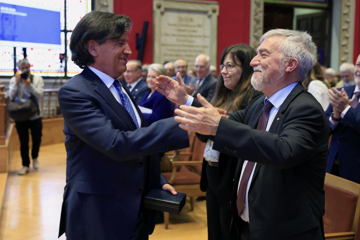 El bioquímico Carlos López Otín es felicitado por el profesor aragonés Mateo Valero, este martes en el Paraninfo.
