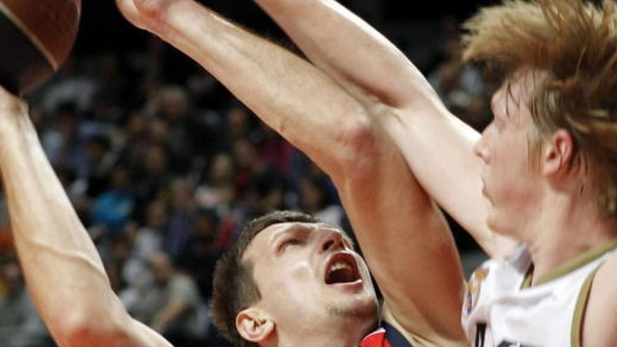 El ala pívot del Caja Laboral Mirza Teletovic trata de lanzar a canasta ante el alero del Real Madrid Kyle Singler.