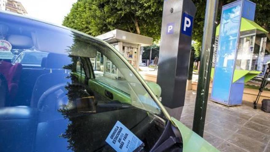 Un coche estacionado junto a la máquina para pagar por el estacionamiento en zona azul.