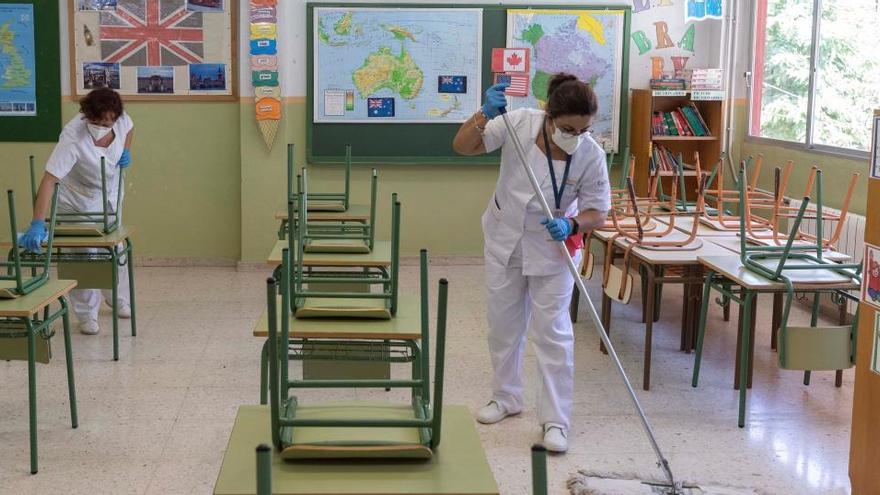 Dos trabajadoras preparan un aula de un colegio de Murcia.