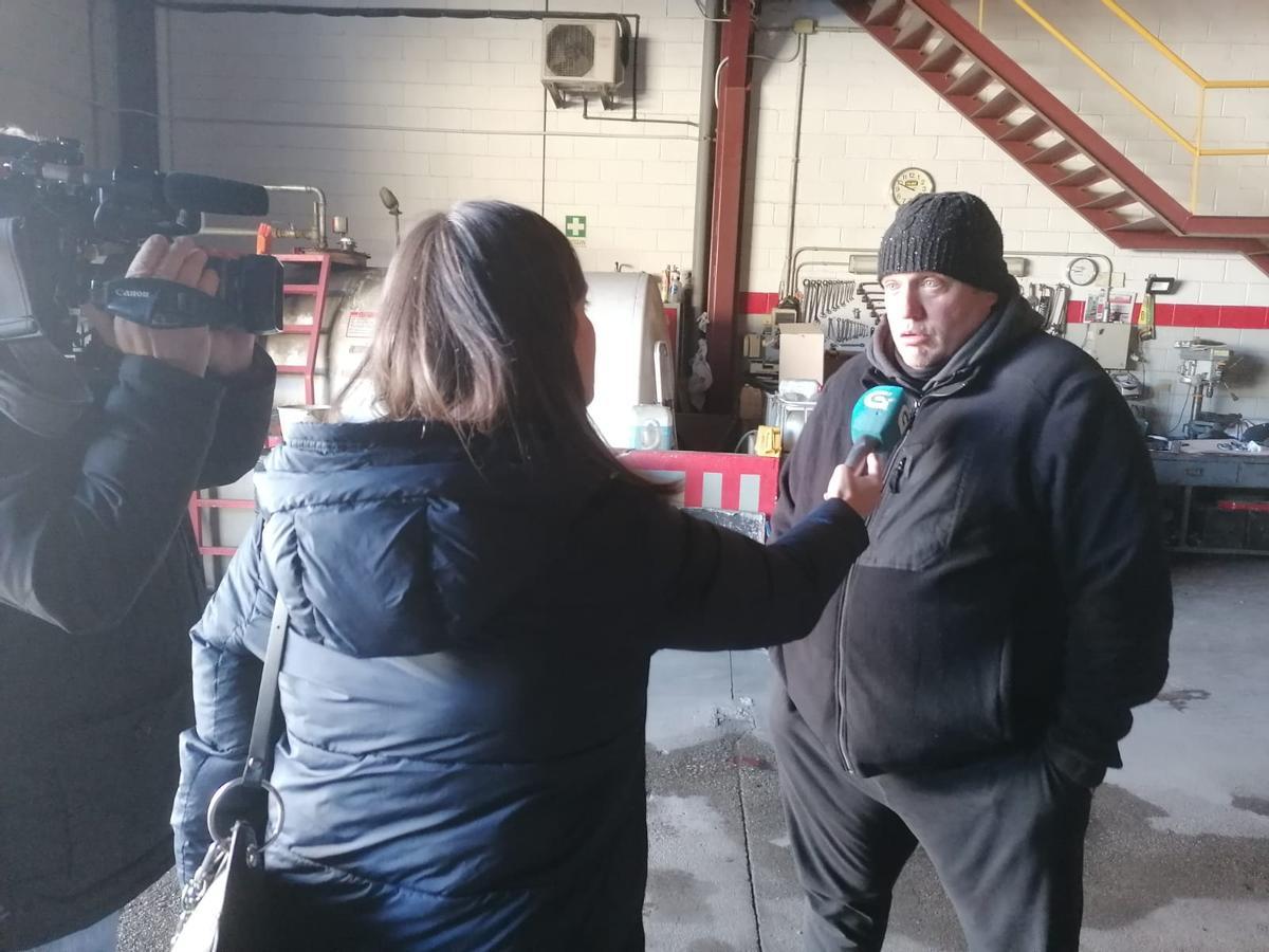 Un conductor de Transportes Rivas atiende a la prensa en la nave de la empresa en Betanzos.