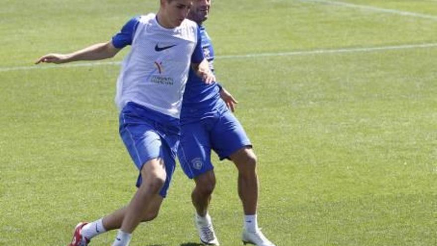 El joven Lauren Egea pugna por el esférico en un entrenamiento del Hércules con el capitán, Paco Peña.