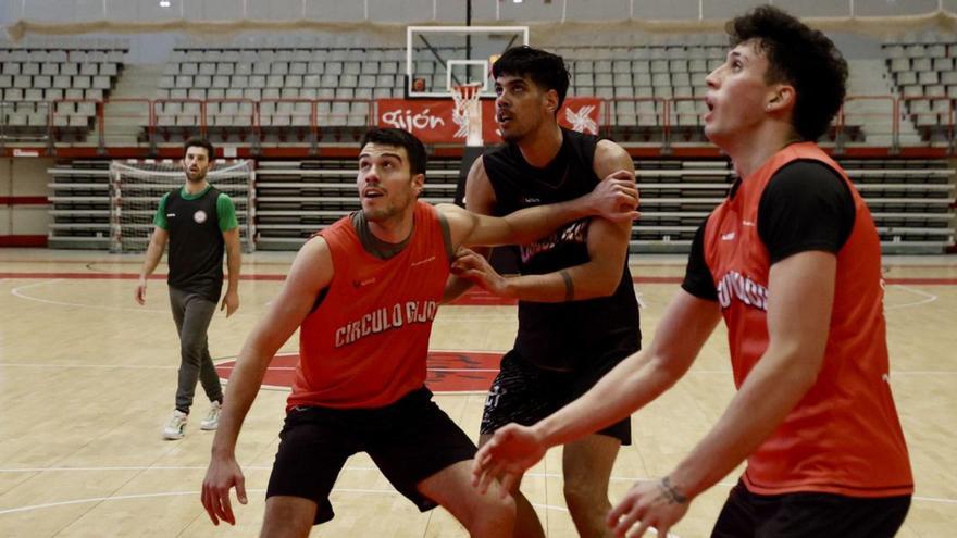 Javi Menéndez y Alberto Díaz, en el centro, pugnan por la posición para capturar un rebote en un entrenamiento, con Samu Barros al fondo y David Ramírez a la derecha.