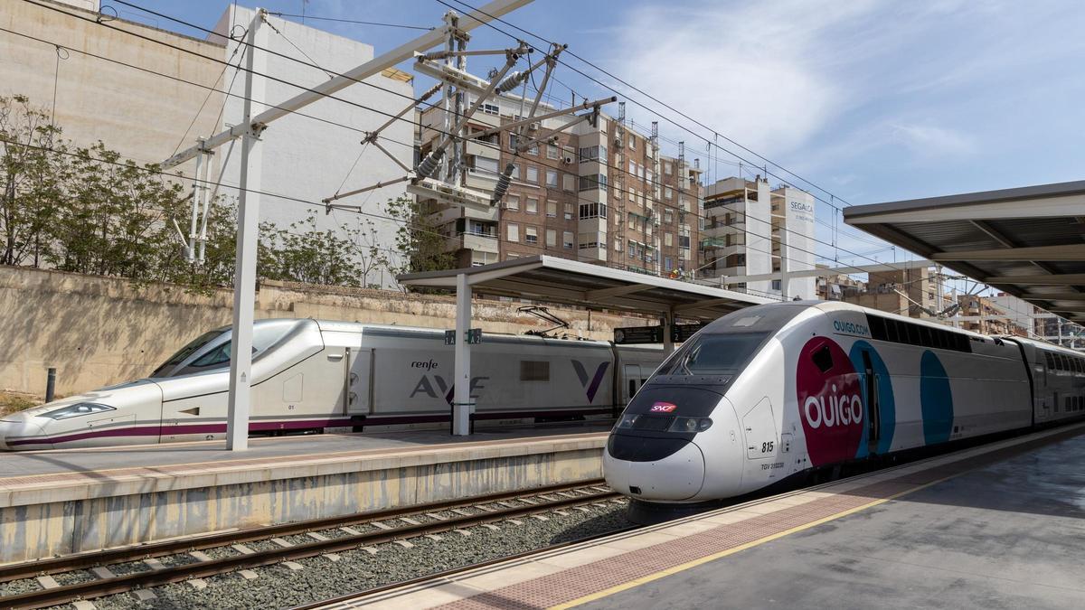 Un tren de alta velocidad de la compañía Ouigo en la estación de tren de Alicante junto a otro tren del AVE.