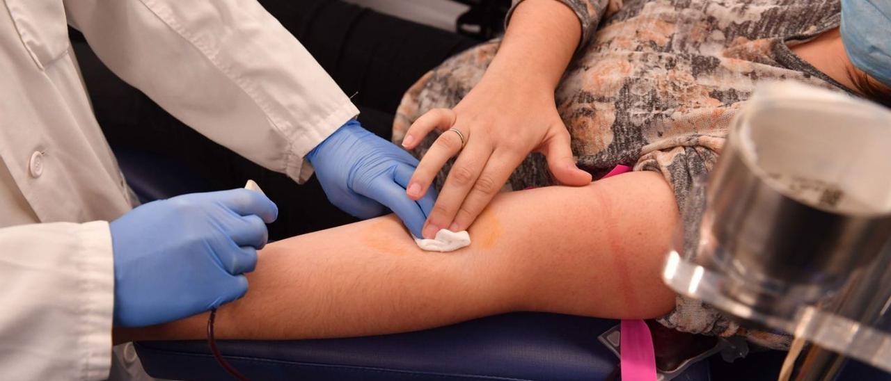 Personal sanitario se dispone a colocar una vía a una mujer para llevar a cabo una extracción sanguínea en una unidad móvil de la Axencia de Doazón de Órganos e Sangue (ADOS).