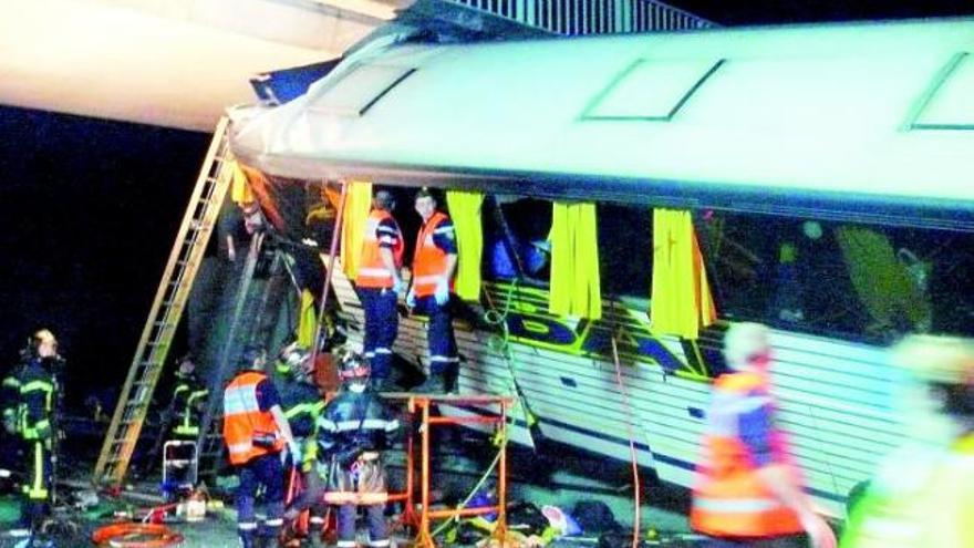 Un grupo de bomberos trabaja en las labores de rescate en el autocar accidentado.