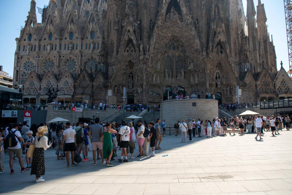 Gente refugiándose del sol y el calor en la Sagrada Familia de Barcelona.