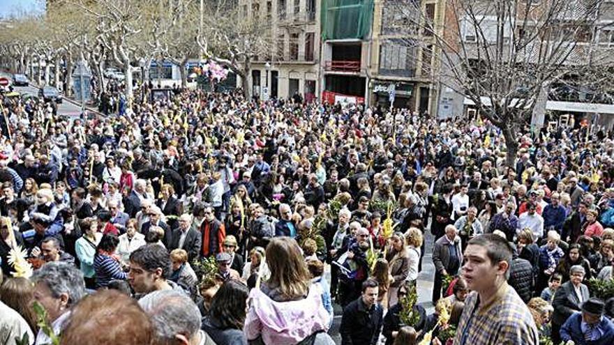 La plaça de Crist Rei plena de gent esperant per beneir els rams, una imatge que enguany no es produirà