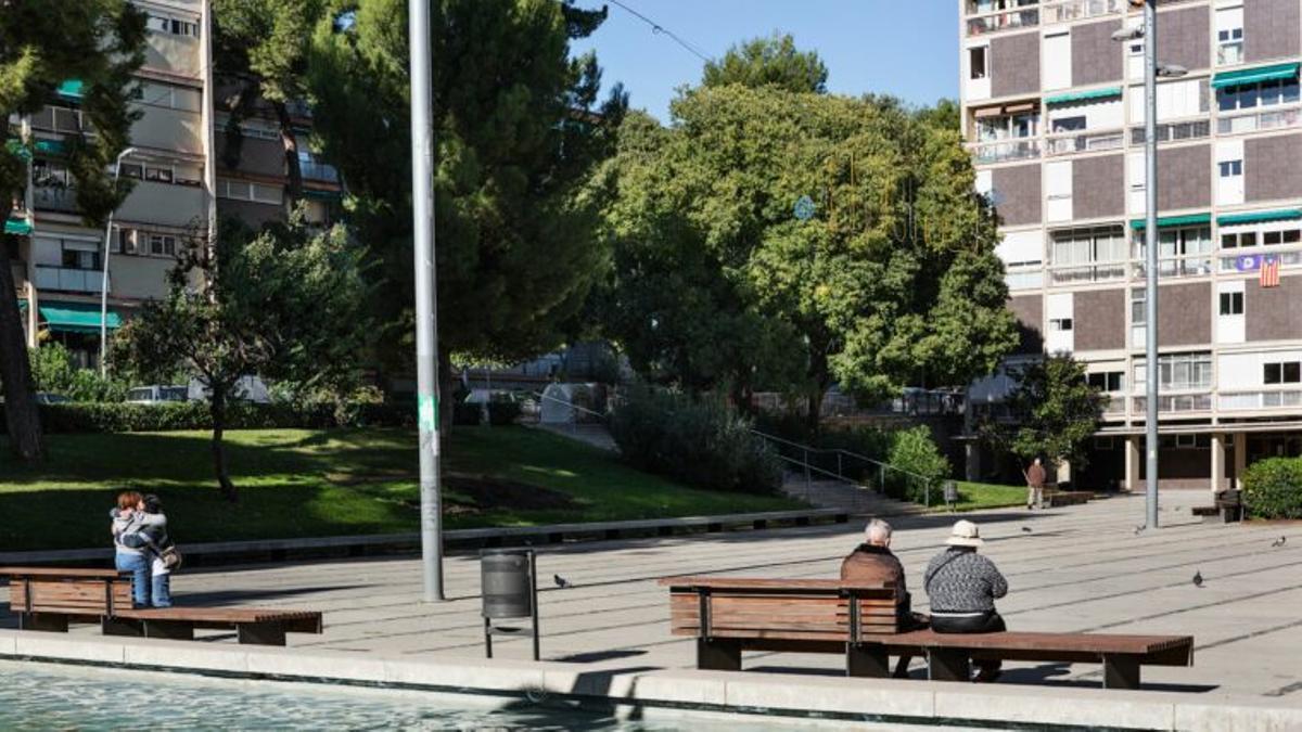Una plaza de Barcelona con varios vecinos sentados al sol