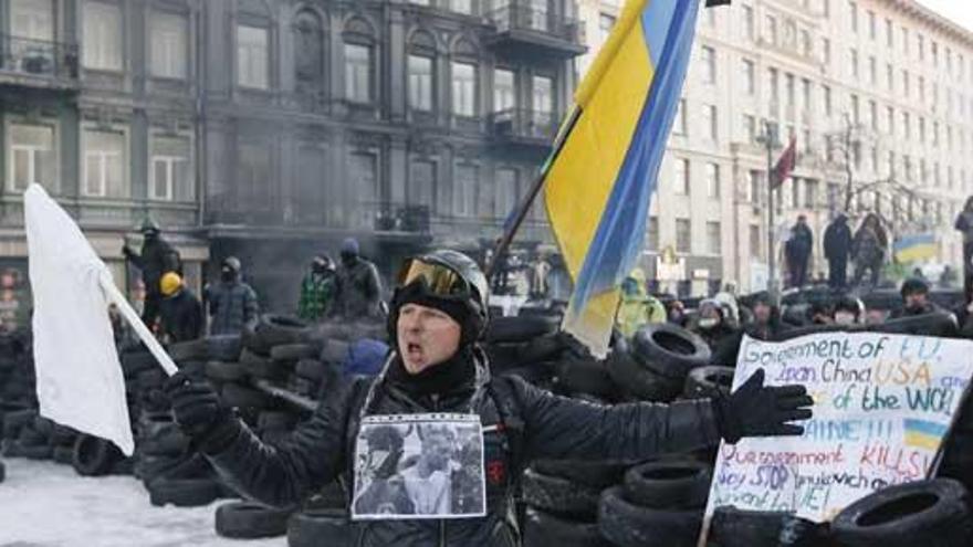 Un manifestante ucraniano, ante una barricada.