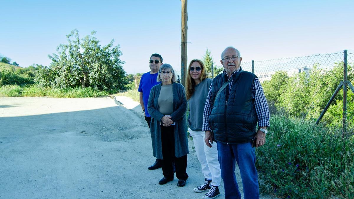 Grupo de vecinos de calle El Oboe, en Monte Dorado, con el tramo terrizo detrás.