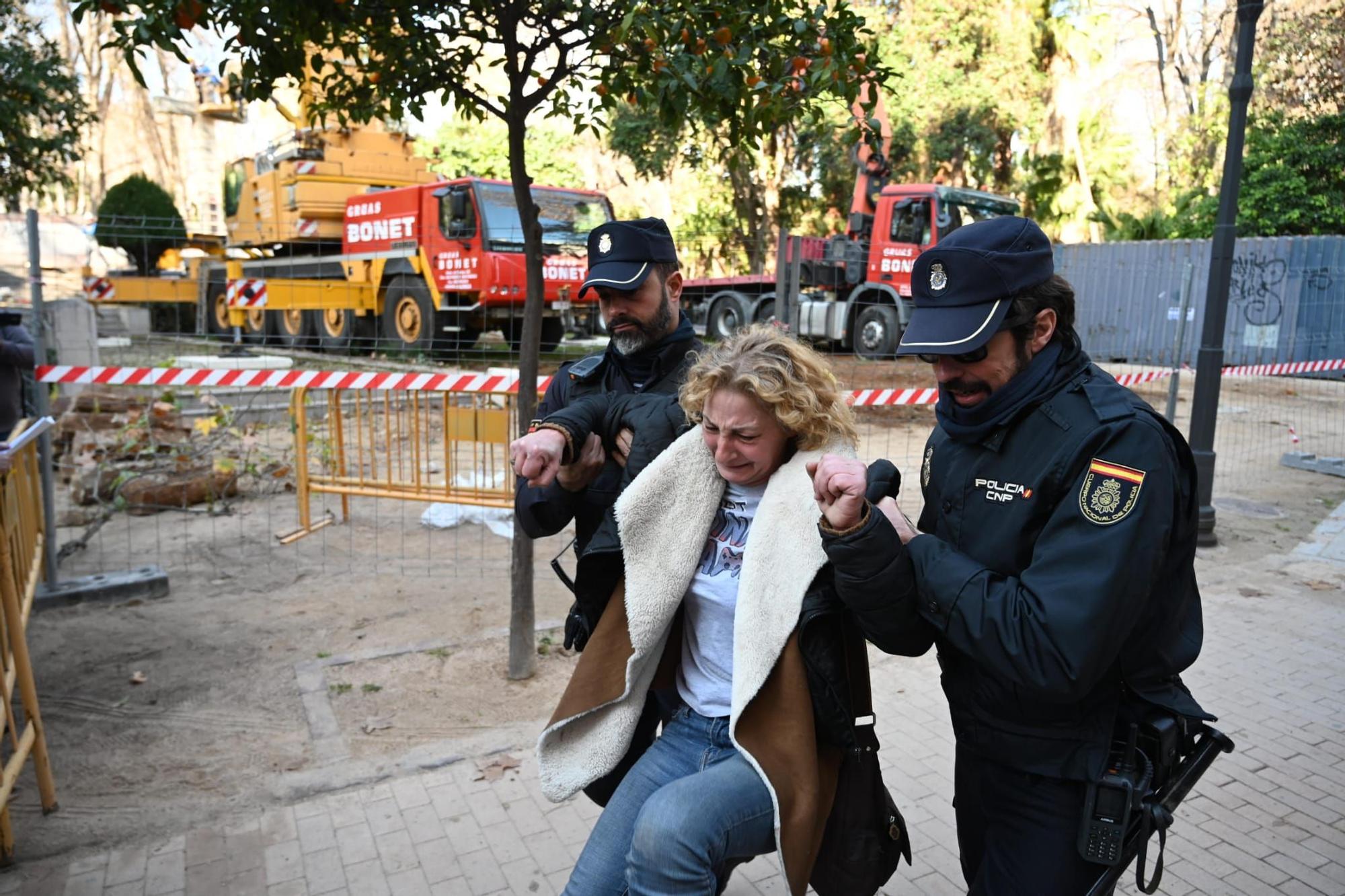 Una señora entra en el recinto vallado y es retirada por agentes de la Policía Nacional.