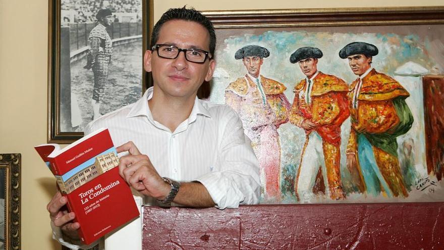 El pregonero de las fiestas de Blanca, Manolo Guillén, posa con su libro ´Toros en La Condomina´.