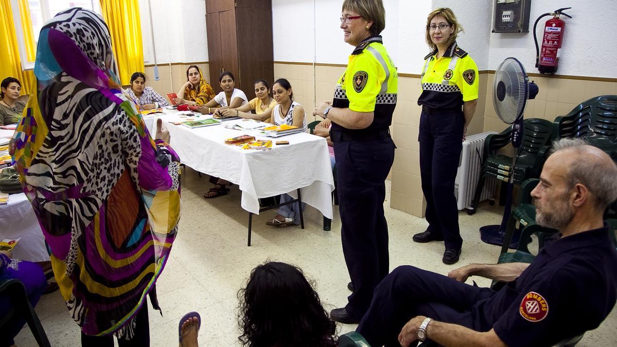 Barcelona ( Barcelones) 09.07.2010. Barcelona. Primera sesion informativa de seguridad viaria y de proteccion por causa de incendios, dirigida a recien llegados. sesion con mujeres pakistanis. Arxiu DG. 100709 ex 7141 JP en la foto: El bombero, Xavier Garcia, en la sesion informativa de proteccion frente al fuego y las policias locales, Maribel Cruset y Concepcion Magriña ( de izq a der.), sobre proteccion viaria. Foto Joan Puig