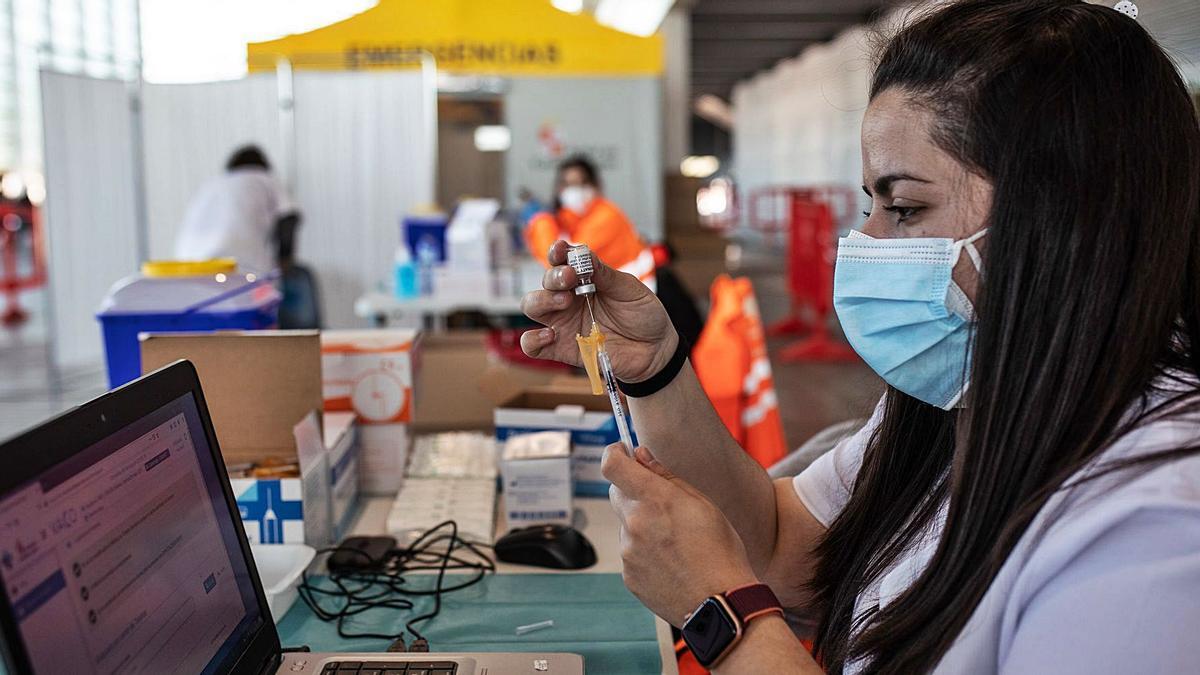 Una sanitaria prepara una vacuna en el recinto de Ifeza.