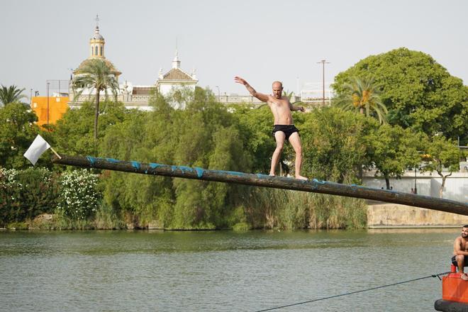 La 'cucaña', el juego centenario que regresa cada verano al río Guadalquivir por la Velá de Santa Ana en imágenes