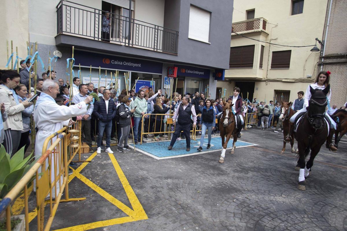 Caballos y jinetes desfilan por la Plaça Major, ante la bendición del párroco, en la Romeria de la Llosa.