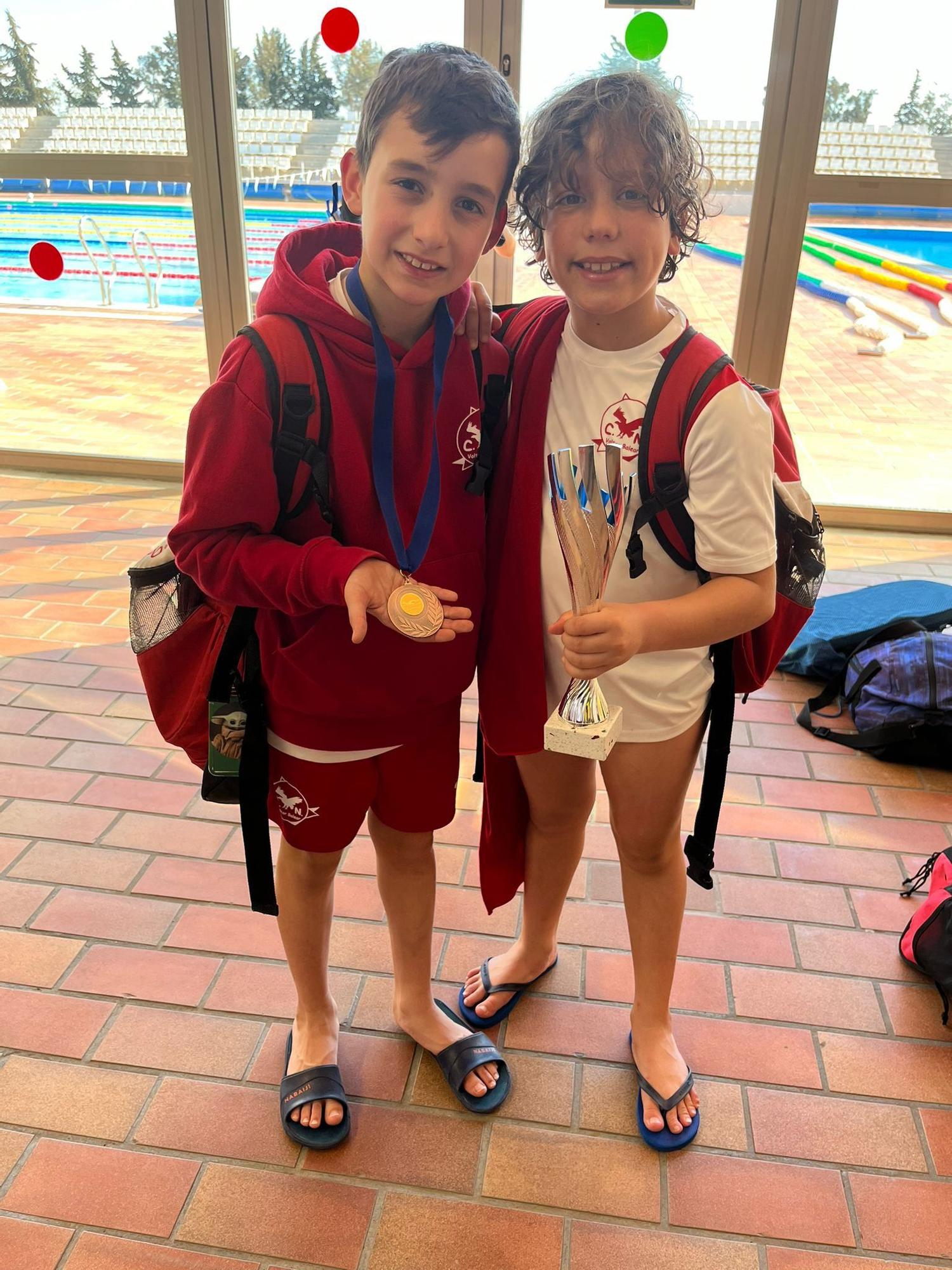 Dos jóvenes nadadores del CN Voltor Balear con sus trofeos