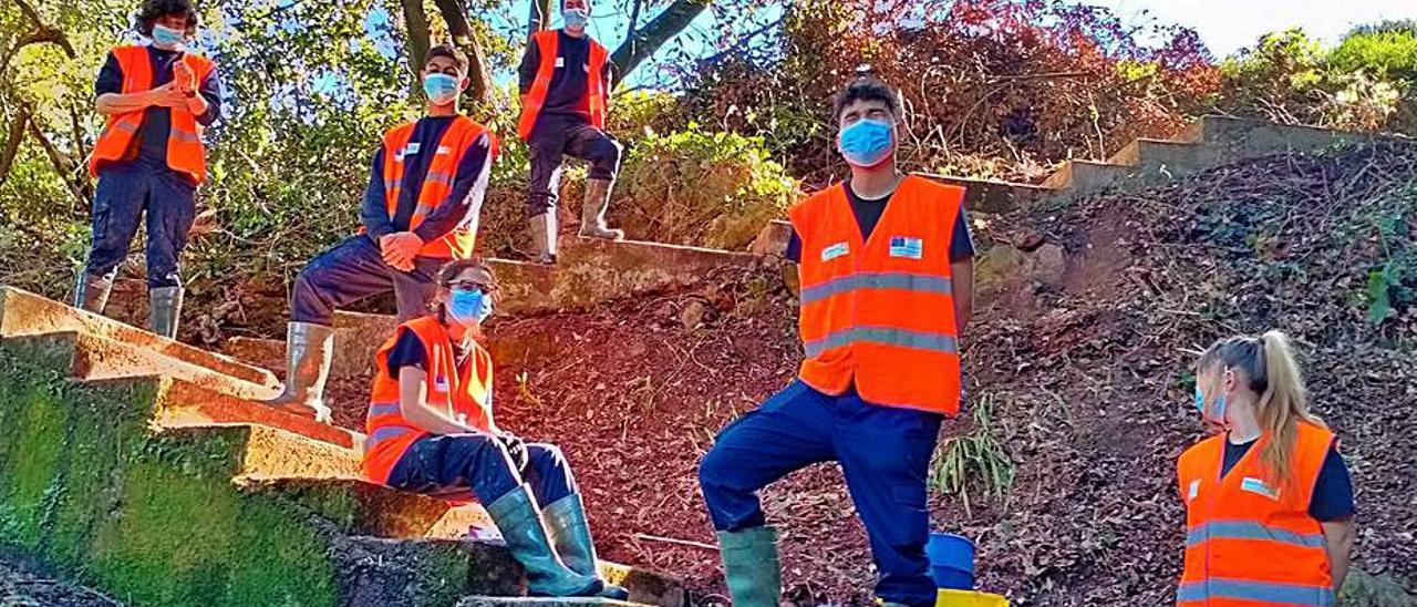 Arriba, un grupo de alumnos del plan “Joven Ocúpate” y obras en el lavadero de Canal, en Laviana.