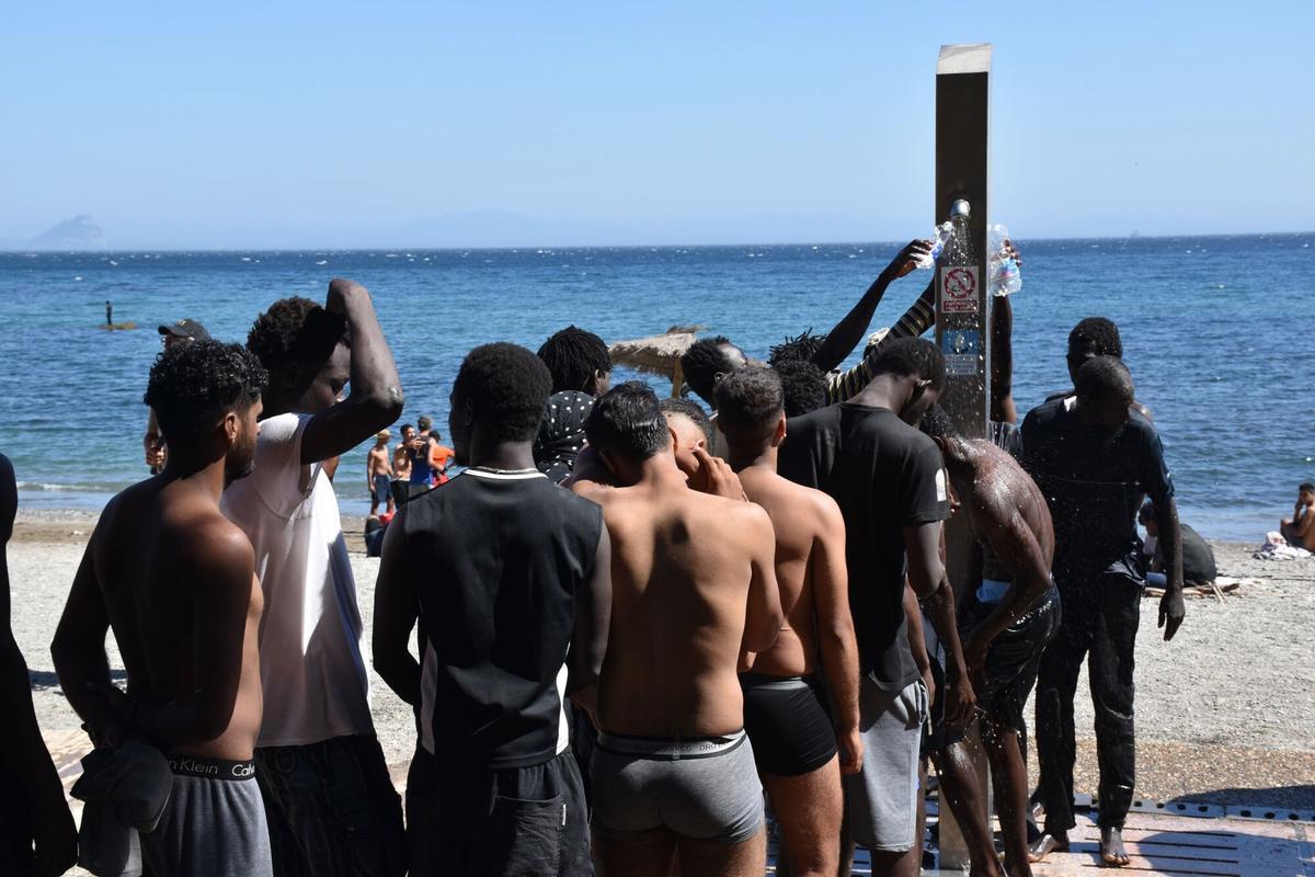 05/08/2026 Varias personas se asean en las duchas públicas, en la playa del Trampolín, a 5 de agosto de 2026, en Ceuta (España). La Policía Nacional ha comenzado el proceso de triaje de los migrantes que permanecen en Ceuta, "unos 2.500" según informaciones de la Delegación del Gobierno,  tras la entrada masiva registrada la pasada semana, al objeto de denegar o conceder las solicitudes de asilo. SALUD Gabriela Sardá Núñez - Europa Press