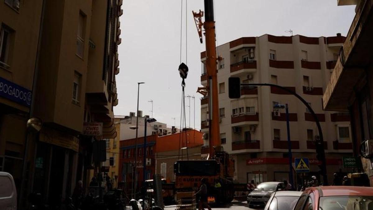 La grúa eleva uno de los conductos junto al edificio donde se encuentra el restaurante asiático.