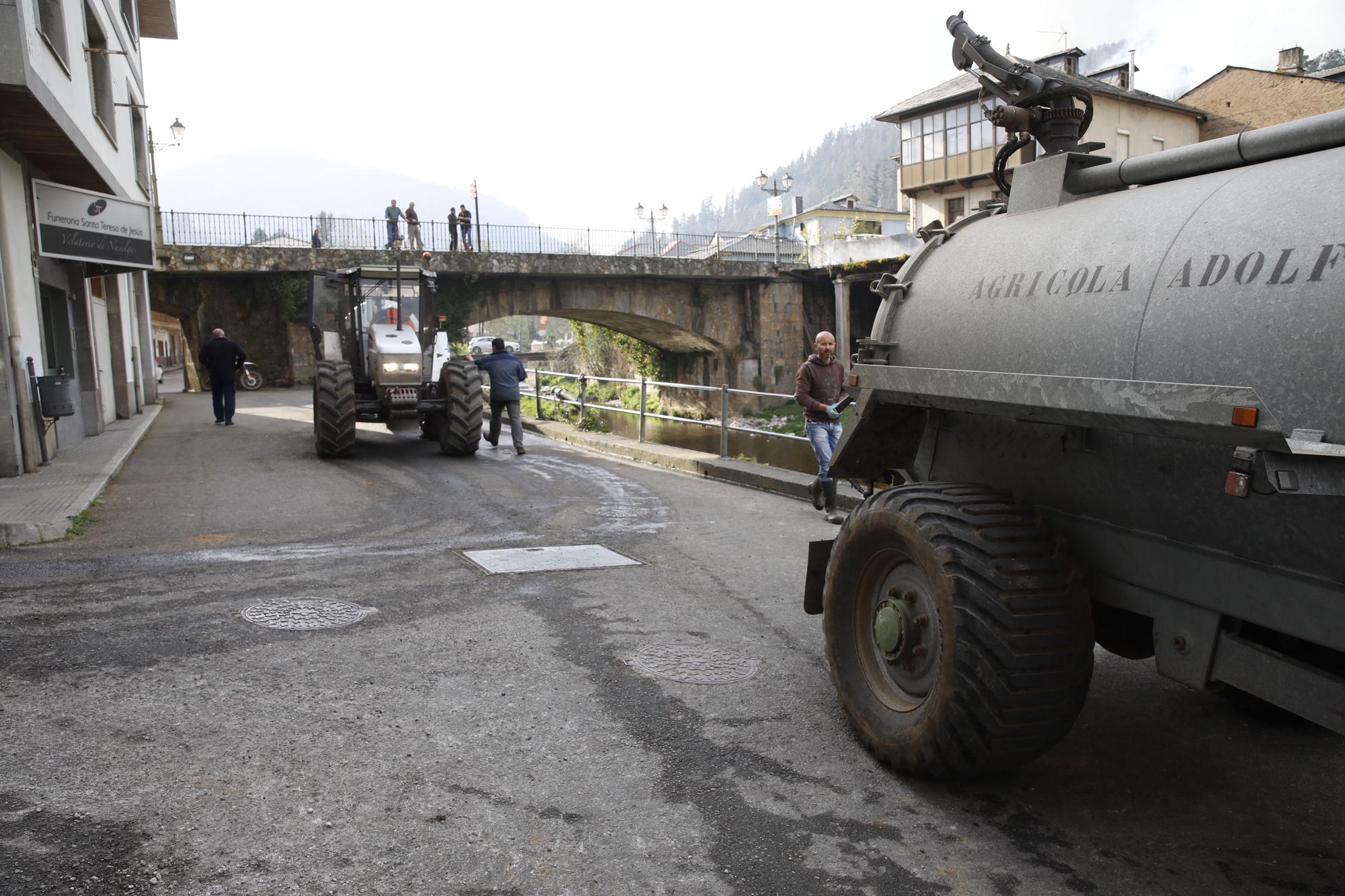 Agricultores ayudando en la extinción de los focos de fuego y enfriando las inmediaciones de la gasolinera de Navelgas