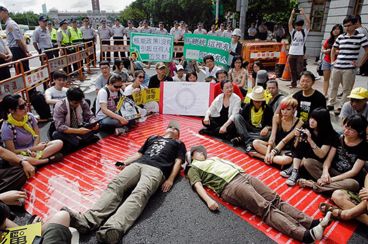 Diversos activistes formen el caràcter xinès ’ren’, que significa ’ésser humà’, durant una protesta en contra de la reactivació de la planta nuclear de Taipower Kuosheng, a Taipei (Taiwan).
