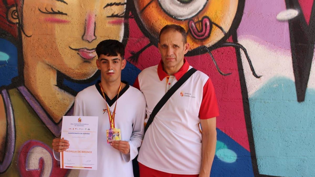 Alberto Garcia posa con su medalla junto al técnico Miguel Huerga.