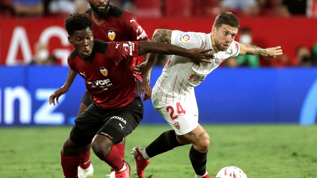 El centrocampista del Sevilla &quot;Papu&quot; Gómez (d) pelea un balón con Yunus Musah (i), del Valencia.