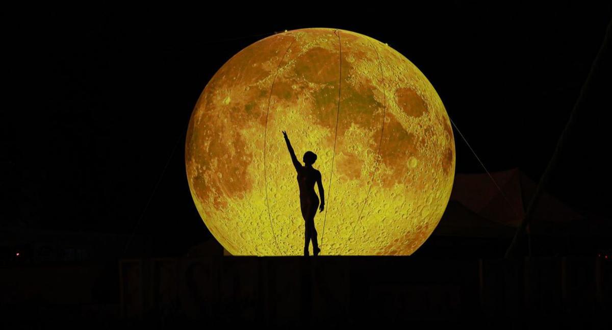 Una bailarina con la luna de fondo al inicio del espectáculo. | TONI ESCOBAR