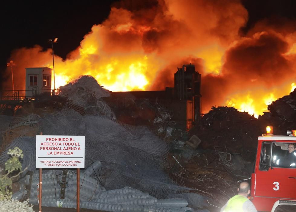 Labores de extinción del incendio de un desguace en Gijón