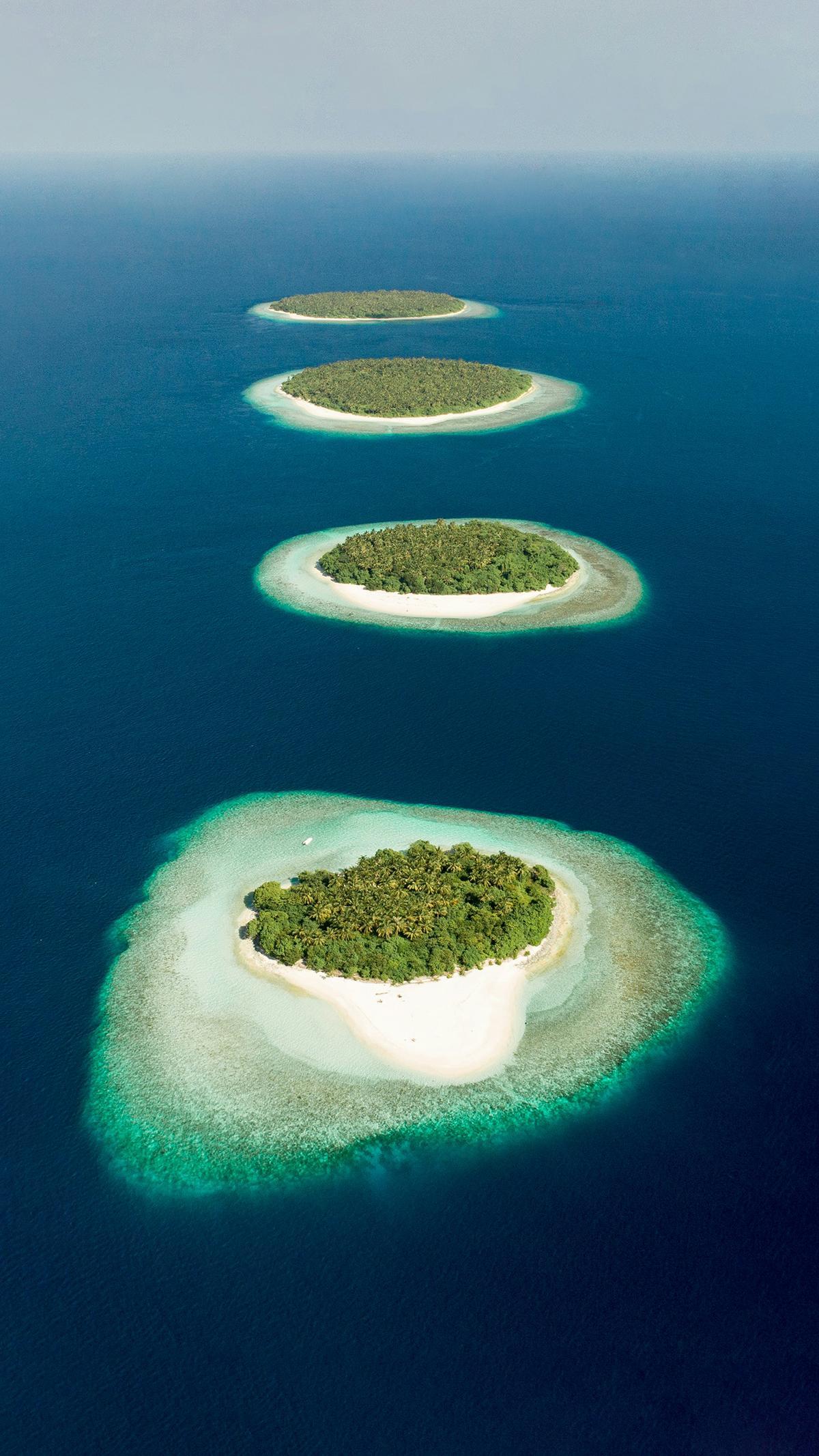 Los atolones de Maldivas dibujan desde el aire un paisaje de islas de coral, lagunas turquesas y arrecifes circulares.