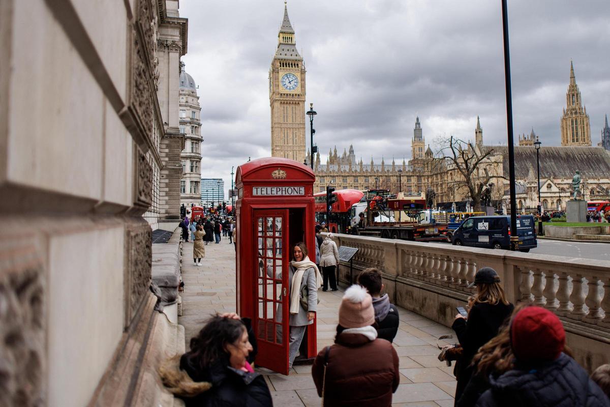Turistas hacen cola para fotografiarse en una cabina londinense frente al Big Ben.