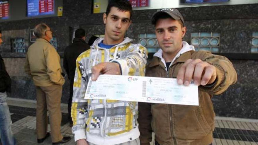 Dos aficionados sostienen entradas del partido de Copa del año pasado