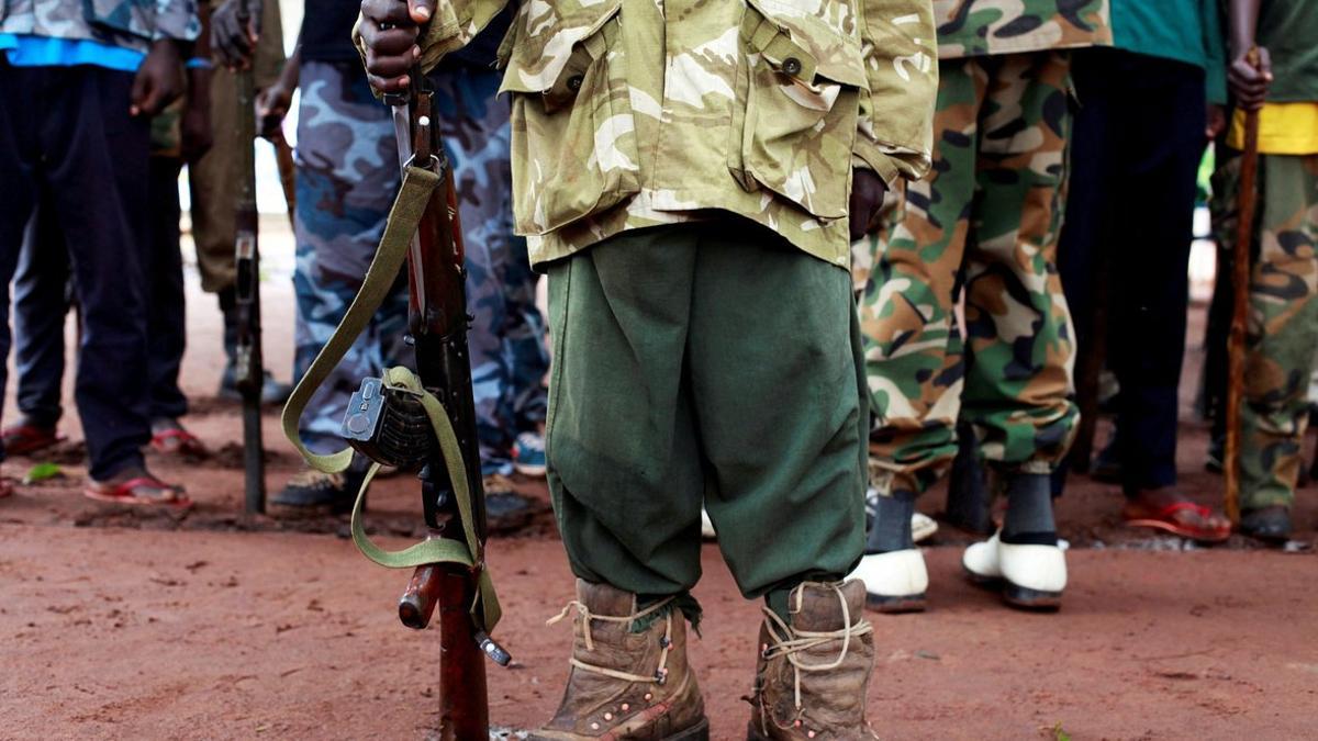 Un antiguo niño soldado sostiene una arma en una cerimonia de liberación de niños soldado en Yambio, Sudán del Sur