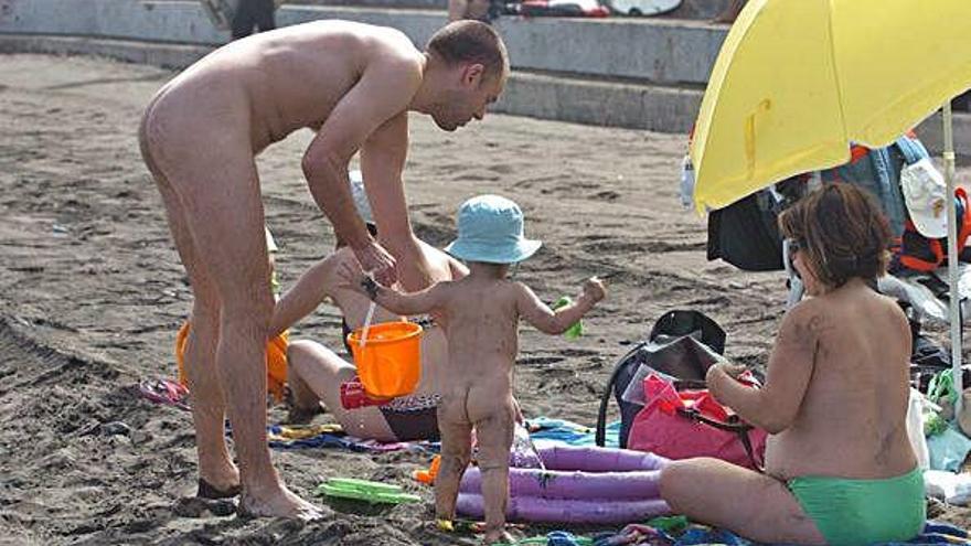 Un nudista en Las Canteras acompañado de su familia.