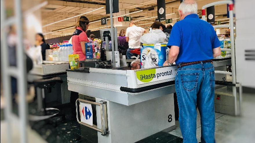 Una cajera atiende a un cliente en un supermercado de la Isla.