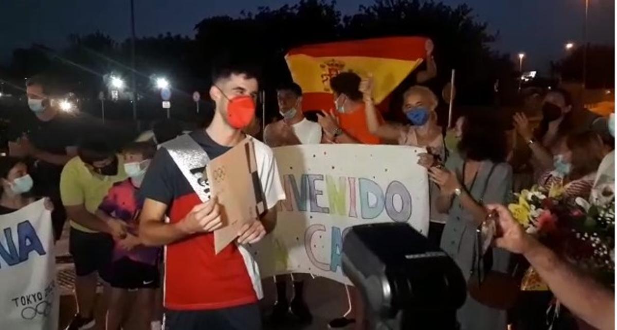 Tur, rodeado de gente, enseña el diploma olímpico. Rafa Domínguez