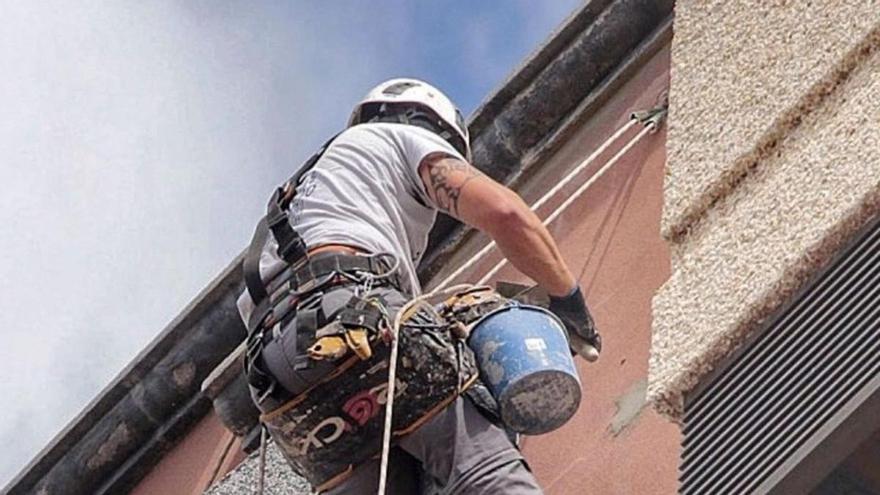 Un operario trabaja en la remodelación de una fachada. | |