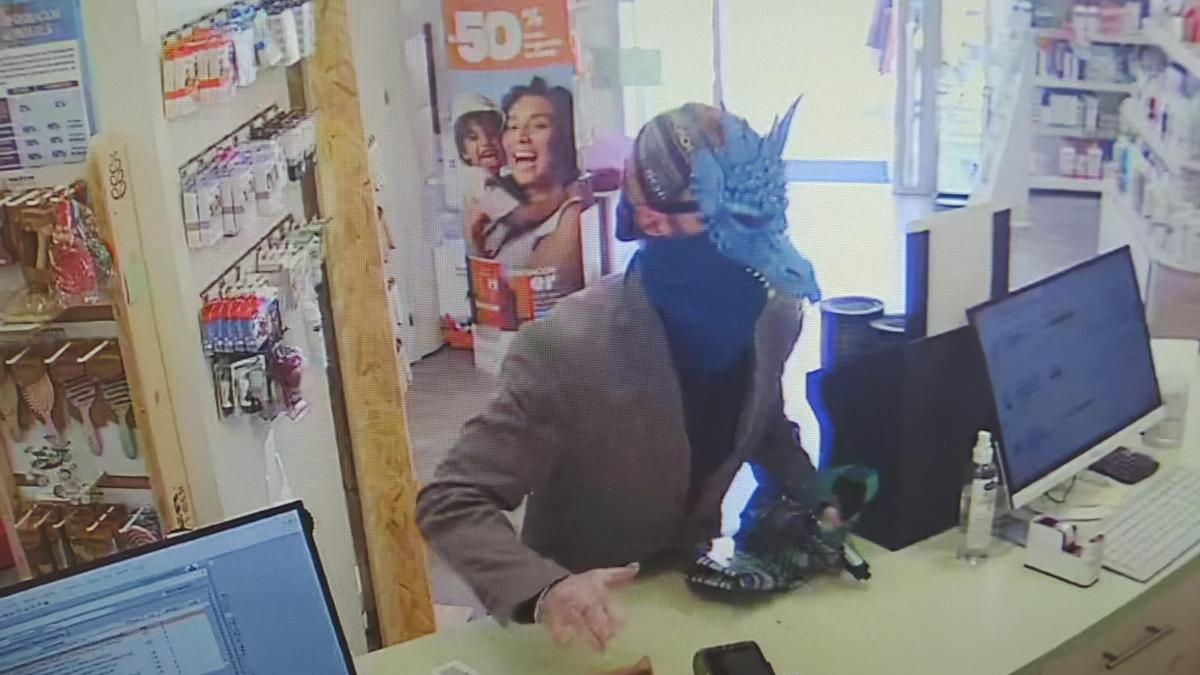 El atracador de una farmacia en Cambre, disfrazado con la cara cubierta por una máscara.