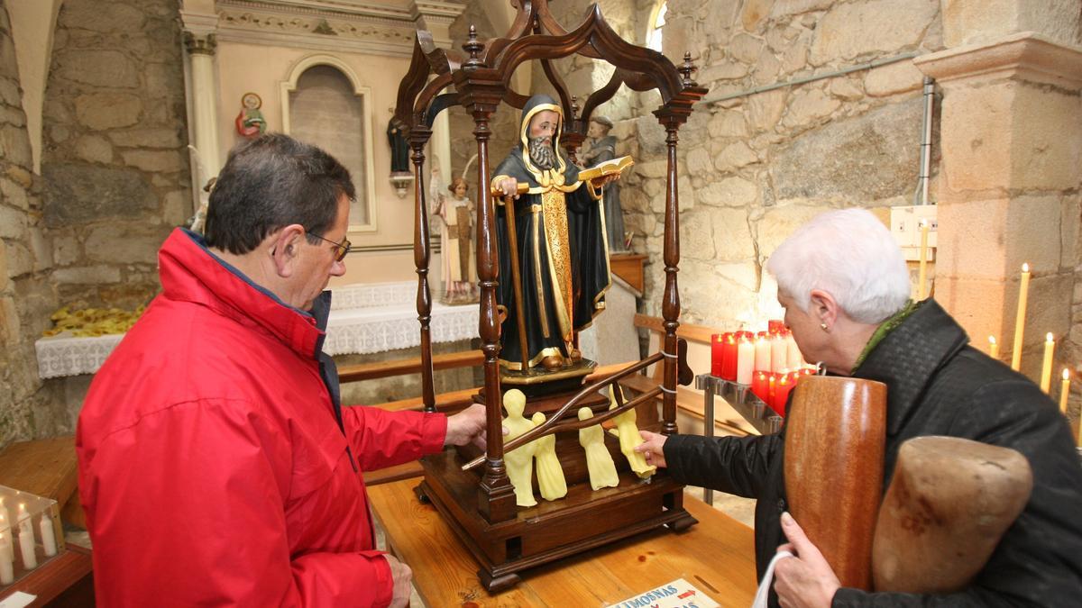 Devotos depositando velas antropomorfas ante San Amaro.