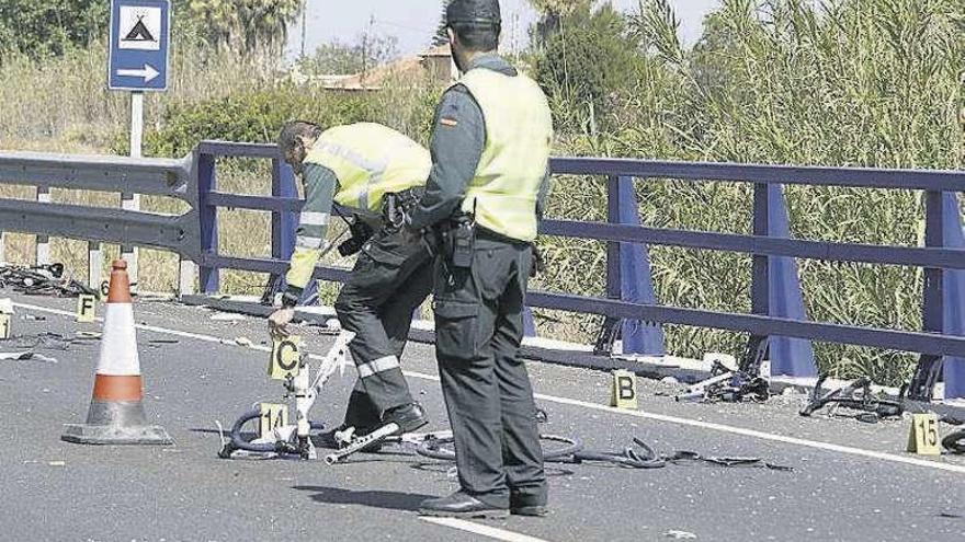 Un guardia civil recoge una bicicleta en la investigación del accidente.