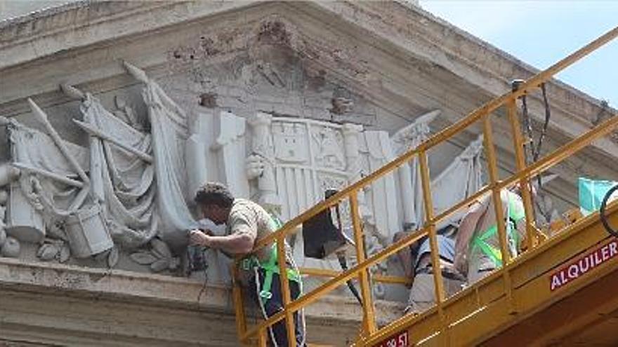 Un operario trata de despegar el cuerpo del escudo de Capitanía, ayer.