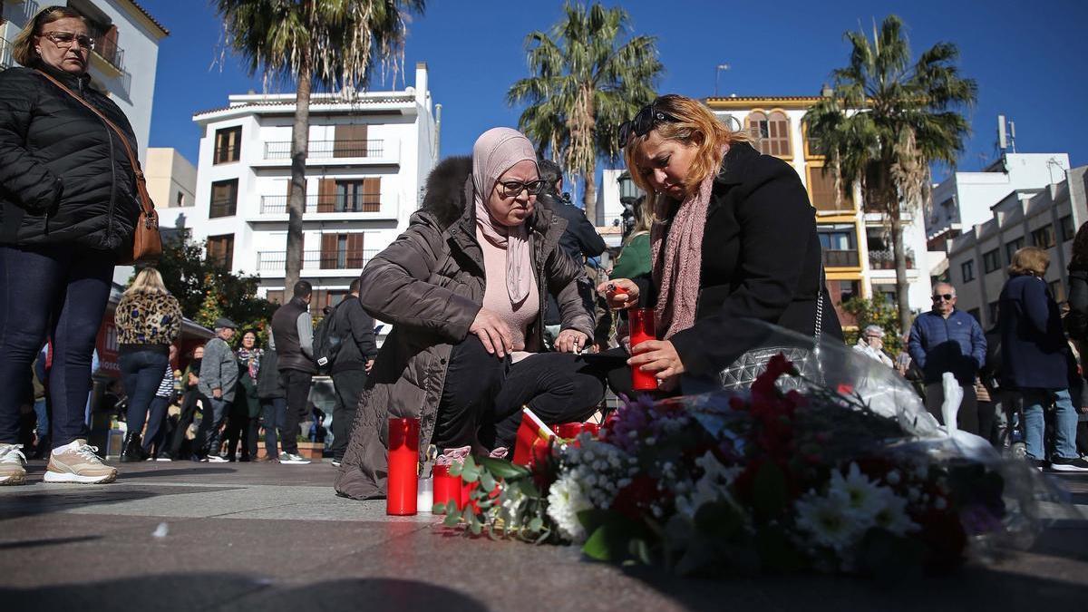 Dos mujeres colocan una vela en el sitio donde asesinaron al sacristán Diego Valencia de la iglesia de la Palma en Algeciras (Cádiz).