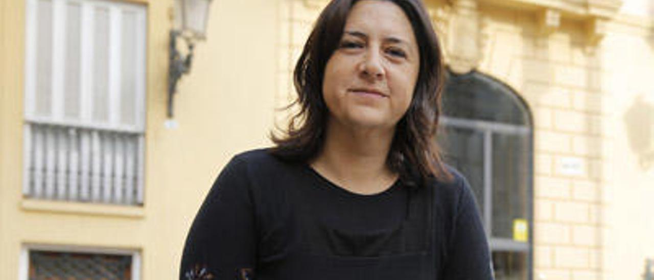 Rosa Pérez, sentada en un banco de piedra frente al edificio de la Diputación de Valencia.